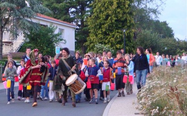 Sonneurs de veuze et tambour en tenue du Moyen-age menant des enfants dans les rues
